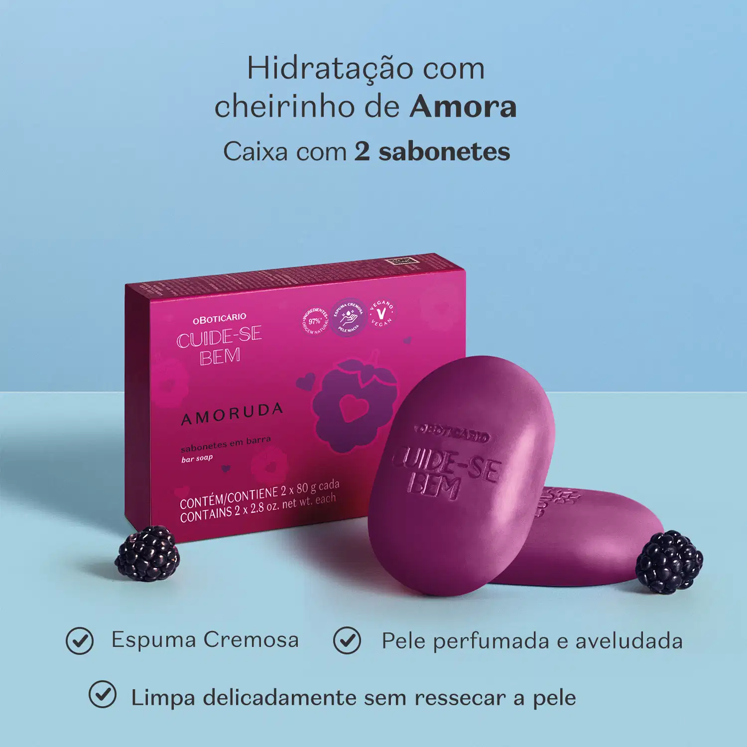 Caixa de sabonetes em barra da marca Cuide-se Bem Amoruda em cor roxa escura e ilustração de amoras, dois sabonetes em barra na cor roxa sobre superfície azul com amoras ao redor. Há letras pretas informando os benefícios do produto.