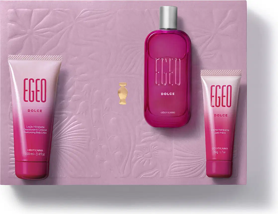 Caixa rosa com flores em relevo e três itens da marca Egeo Dolce, sendo uma bisnaga de creme hidratante para as mãos, outra de loção hidratante corporal e um vidro com tampa prateada contendo desodorante colônia.