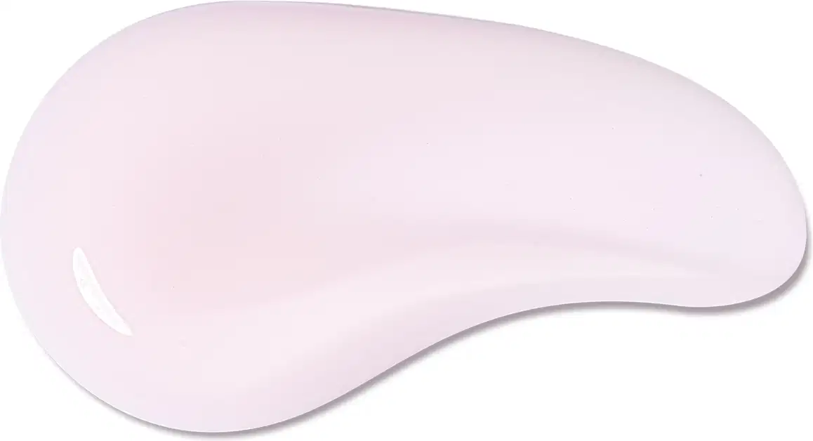 O produto de beleza apresenta uma textura suave e cremosa, com uma cor rosa pálida uniforme. Sua aparência é lisa e sedosa, sugerindo uma consistência delicada e agradável ao toque.