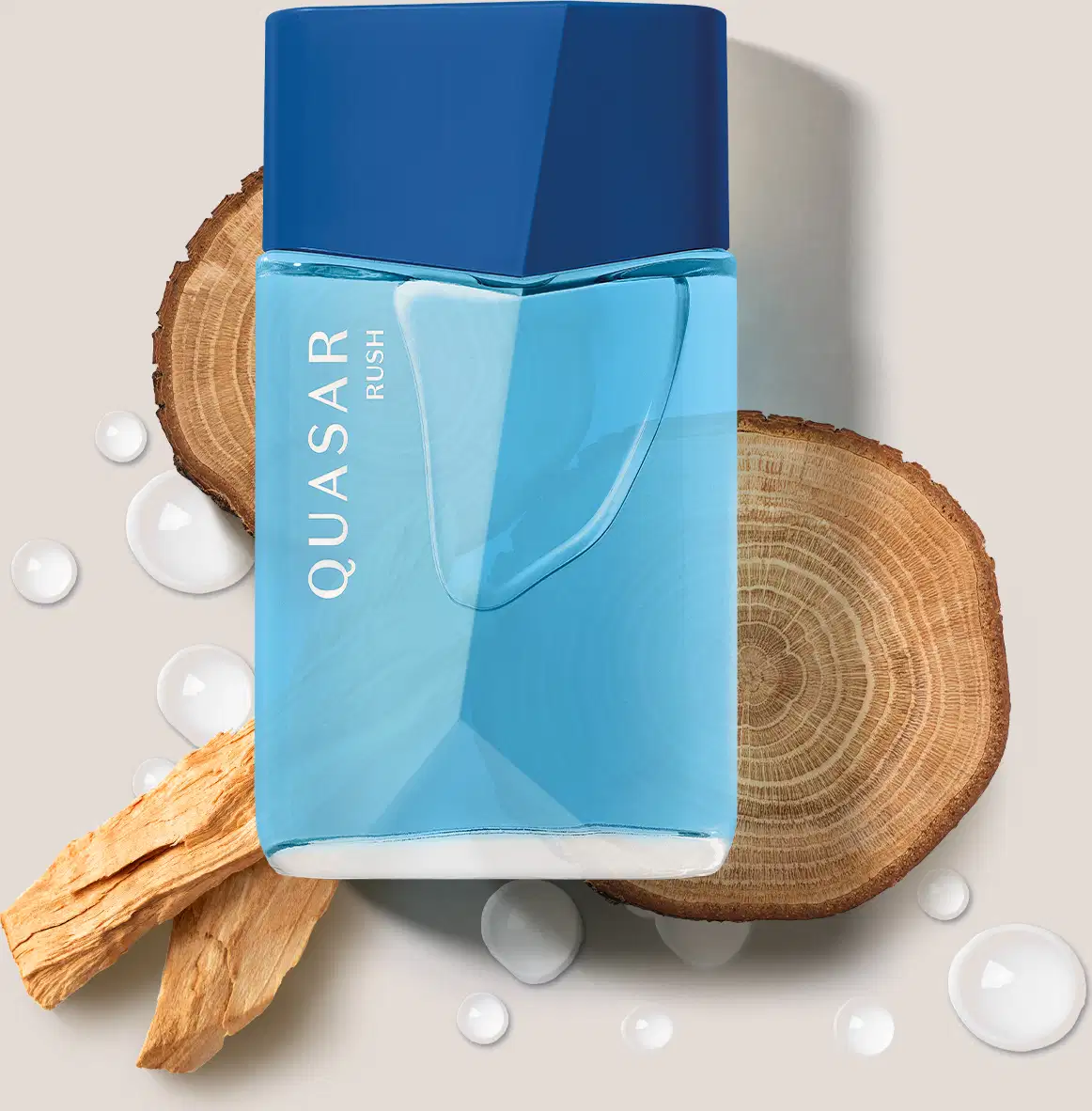Imagem de um frasco de desodorante colônia da marca Quasar Rush em azul-claro com tampa azul royaç, sobre superfície de madeira com pedaços de casca e gotas de água.