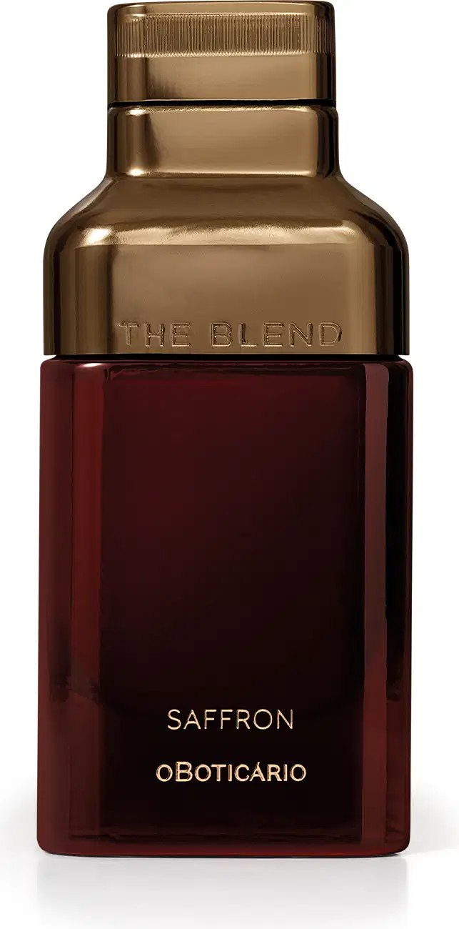 Frasco dourado com rótulo vermelho escuro, contendo o texto "The Blend" e "Saffron oBoticario". O produto possui uma embalagem elegante e sofisticada, com destaque para o tom dourado predominante.
