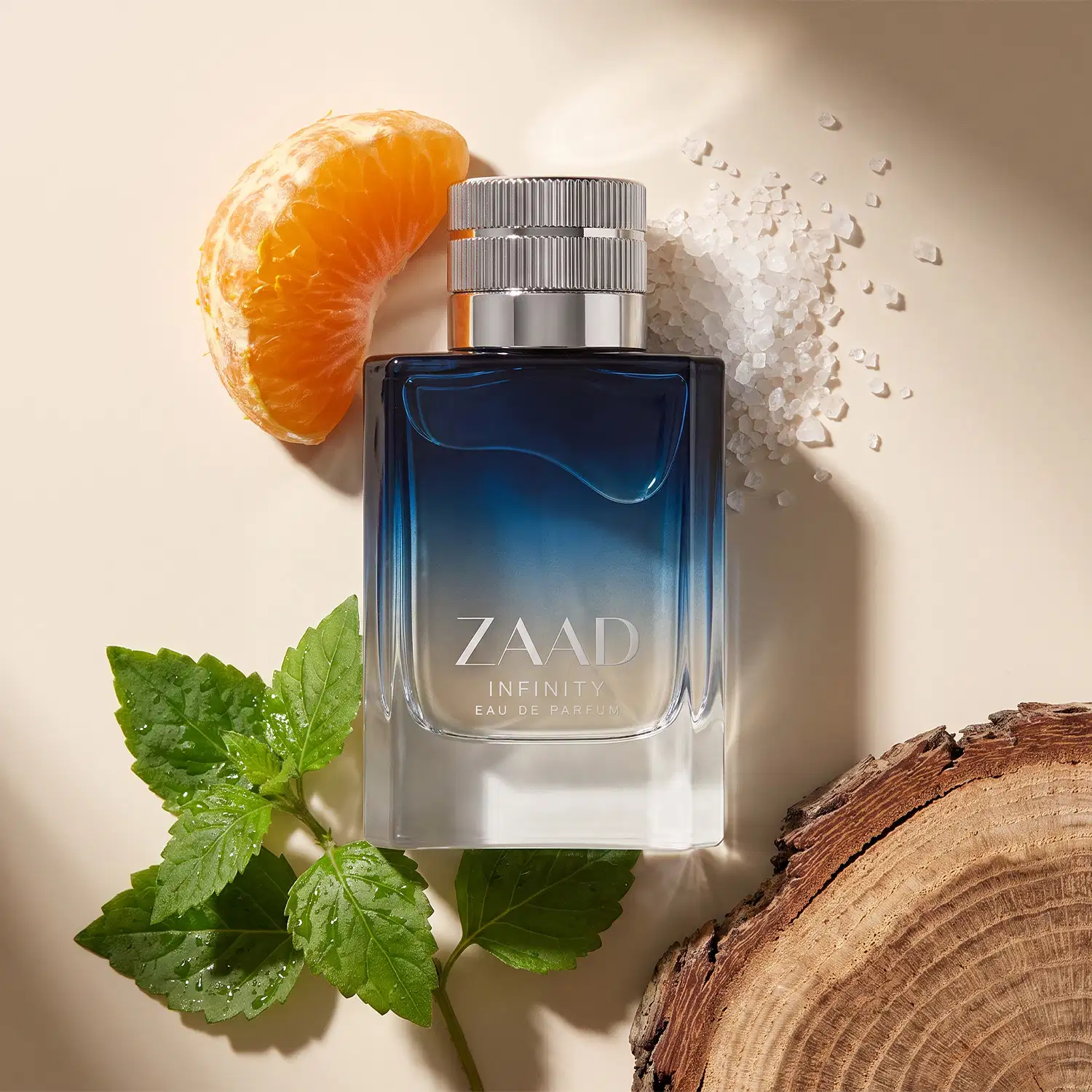Frasco de item de perfumaria Zaad Infinity sobre superfície de madeira, com tangerina, folhas verdes e cristais de sal ao redor, em ambiente iluminado e neutro.