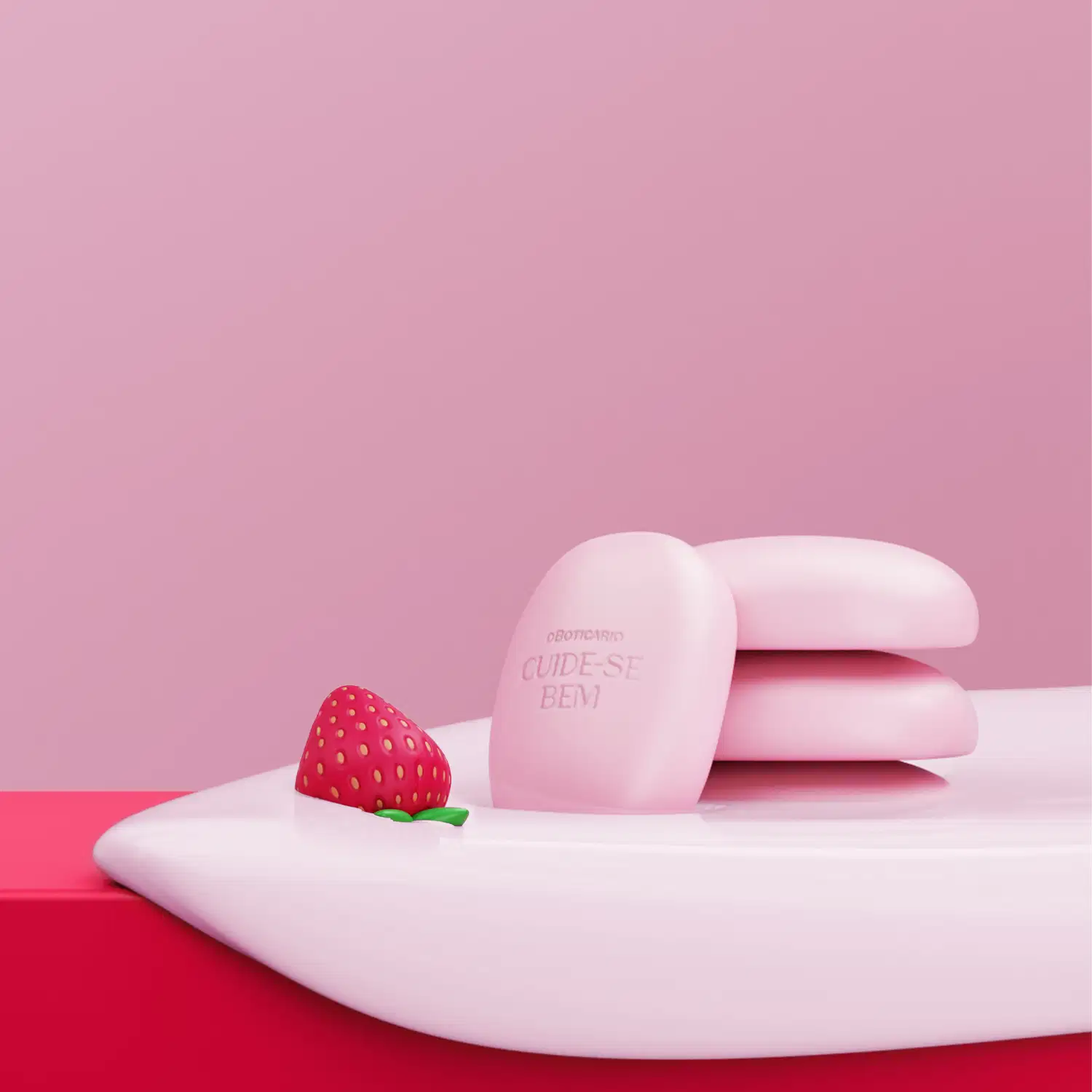 Imagem de quatro sabonetes em barra na cor rosa em superfície rosa com creme branco escorrendo e morango ao lado. O fundo da imagem é rosa.