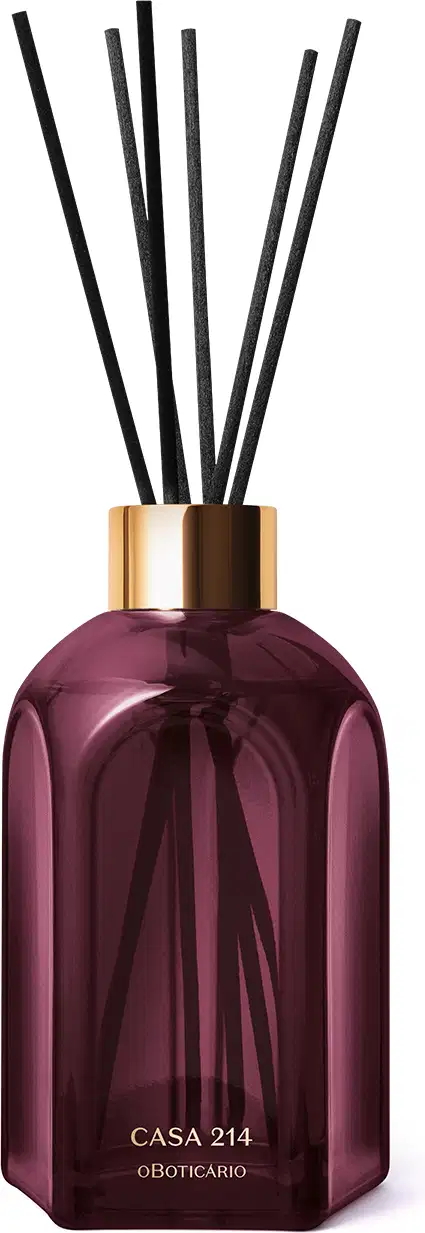 Frasco de difusor de aromas da marca Casa 214, com design geométrico em vidro de cor roxa escura e tampa dourada. Contém varetas de difusão pretas inseridas no frasco.