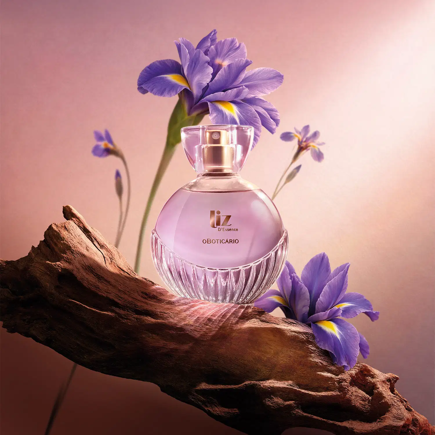 Ambiente de fragrância floral com tons de roxo e rosa, apresentando uma fragrância da marca Liz D'essence em primeiro plano, rodeado por flores de íris em um cenário natural com madeira.