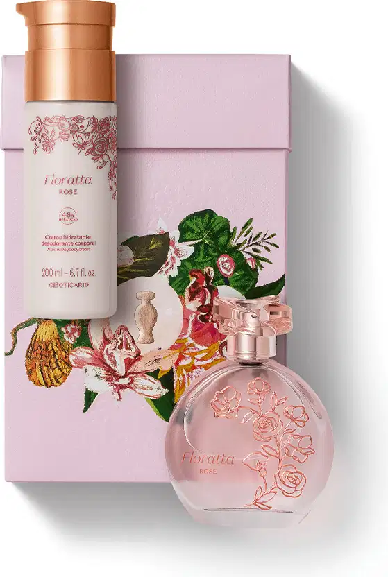 Imagem do kit de presente Floratta Rose, com o clássico vidro transparente do desodorante colônia e um frasco branco creme hidratante corporal, além de uma caixa com estampa floral. As embalagens trazem flores e tampas douradas.