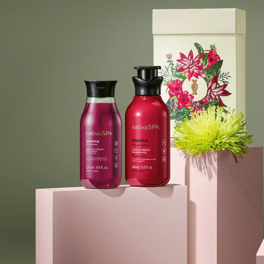 Imagem de kit de presente Nativa SPA Ameixa contendo  um frasco de sabonete líquido, outro de loção desodorante corporal e uma caixa branca com ilustração floral. O kit está sobre quadrados brancos com fundo cinza.