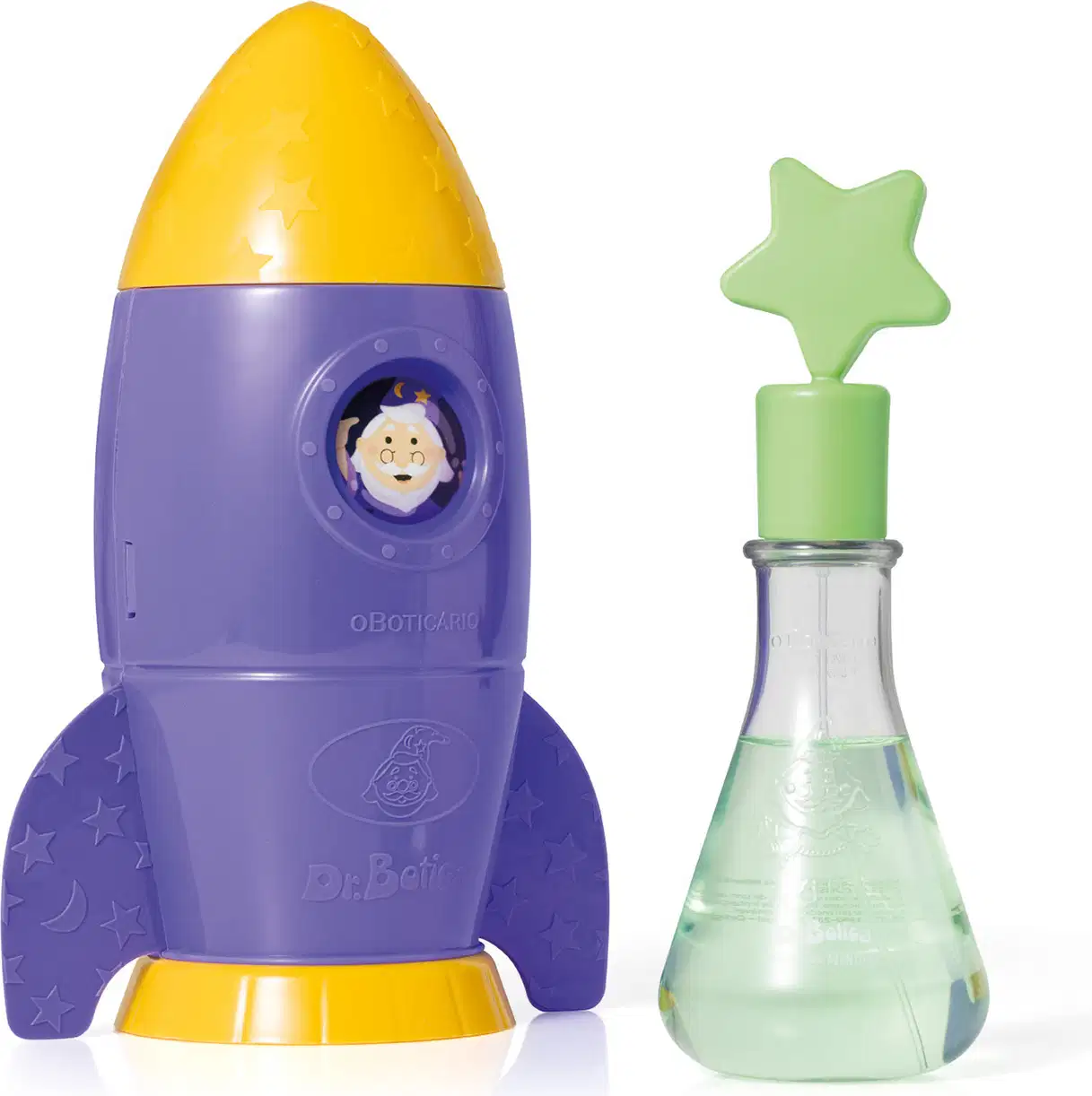 Foguete de brinquedo roxo e amarelo da marca Dr. Botica com estrelas, ao lado de um frasco de vidro verde com tampa em forma de estrela.