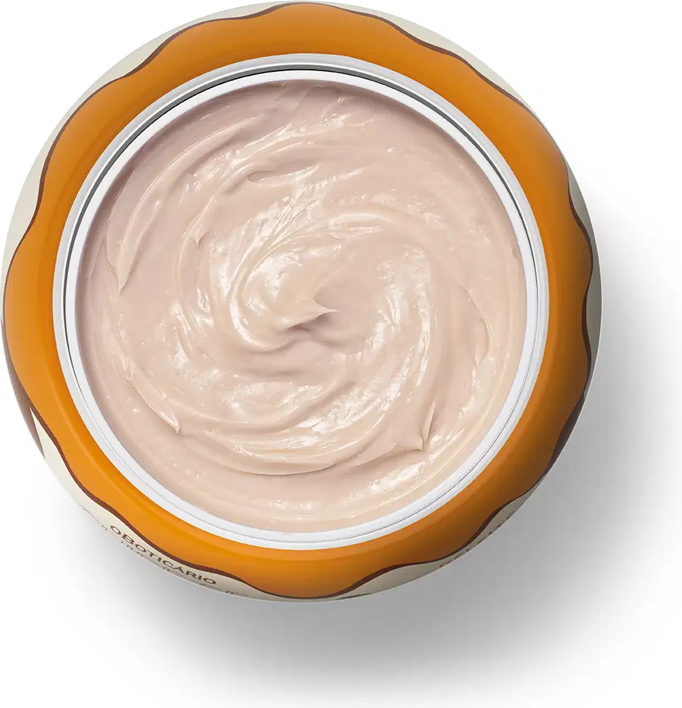 A imagem mostra o recipiente de plástico laranja aberto e contendo um creme branco cremoso e brilhante com textura suave e homogênea.