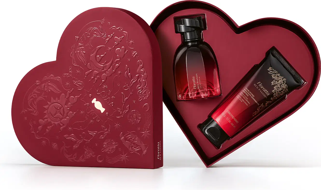 Caixa em formato de coração vermelha aberta e inseridos dentro dela estão frasco de eau de parfum e bisnaga de creme corporal, ambos da marca Floratta Red Passion.