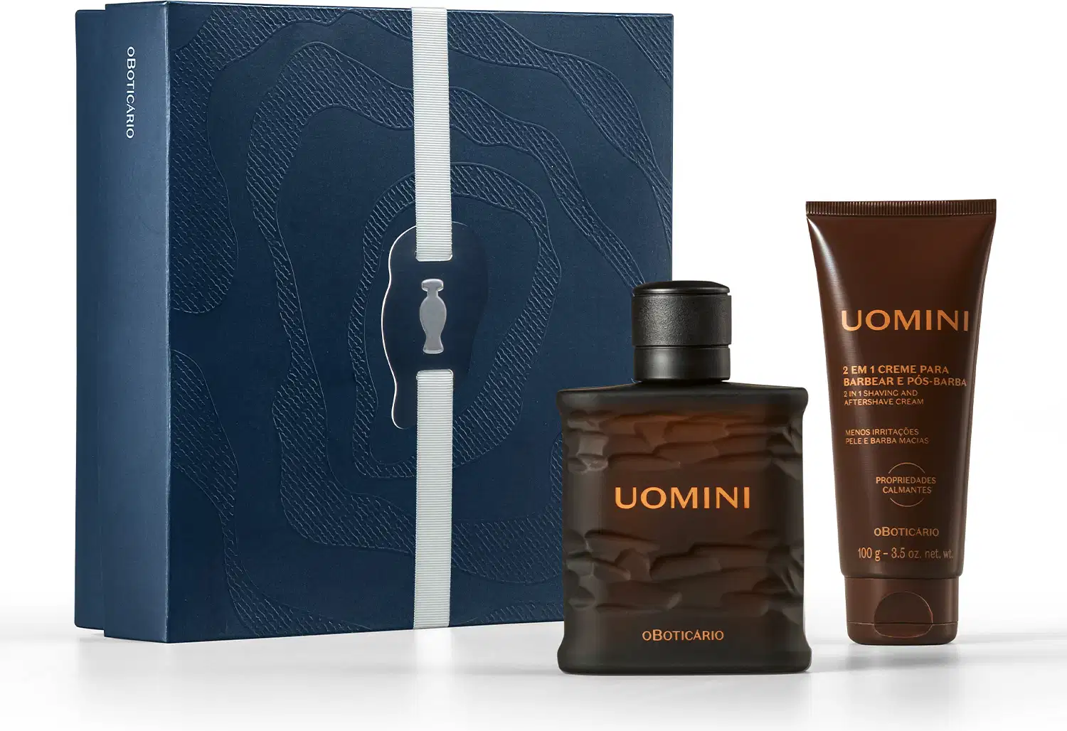 Caixa azul-marinho com padrão ondulado, contendo frasco de item de perfumaria da marca Uomini e tubo de creme pós-barba da mesma marca, em embalagens com cores predominantes preta e marrom.