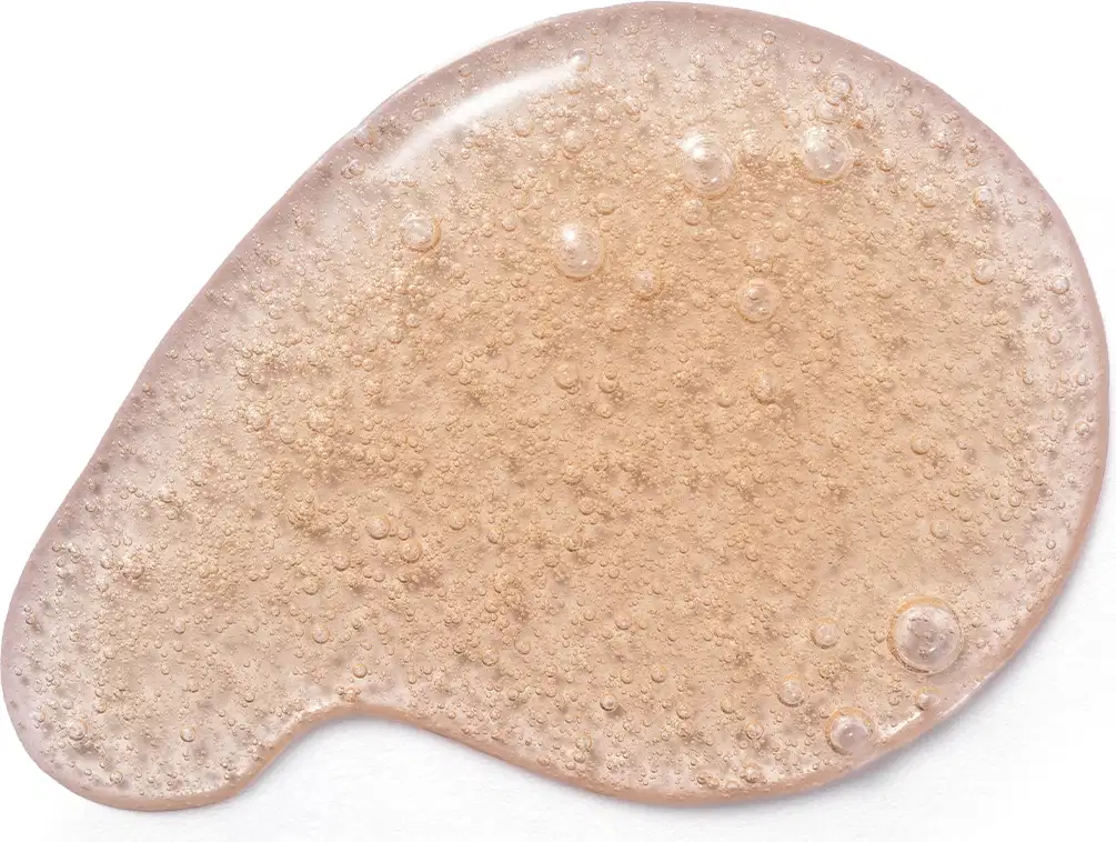 Textura do sabonete líquido Cuide-se Bem Deleite Caramelizado com aspecto granulado, brilhante e úmido, com pequenas bolhas distribuídas uniformemente sobre uma superfície clara.