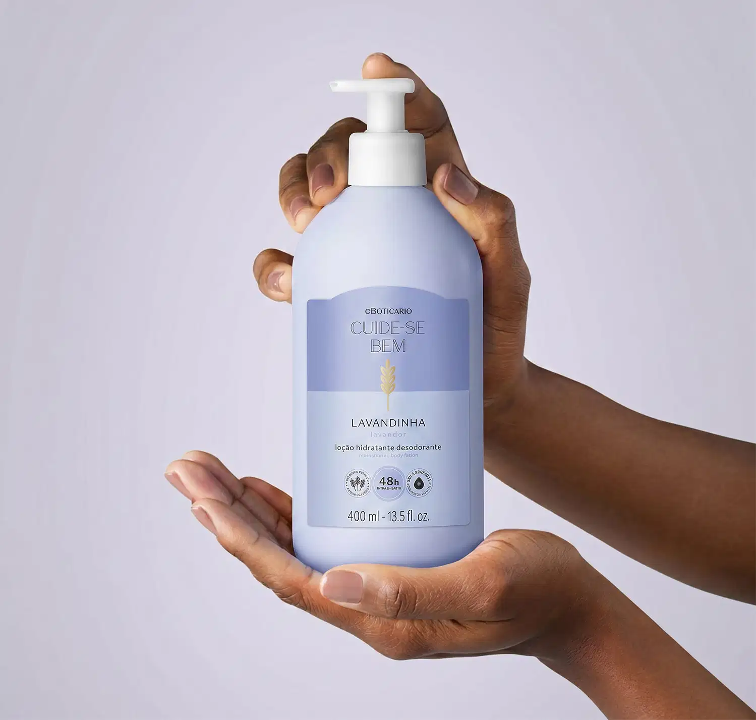 Embalagem branca e azul de um item de perfumaria da marca Cuide-se bem, com bomba doseadora, em mãos contra fundo branco.