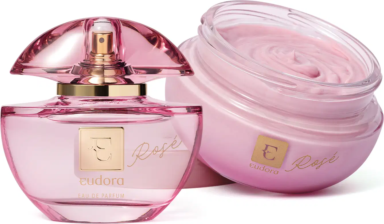 A imagem mostra um frasco de vidro transparente cor-de-rosa com detalhes dourados, contendo um perfume líquido chamado "Rose". O segundo produto é um vidro redondo contendo um creme corporal ou hidratante da mesma fragrância "Rose".