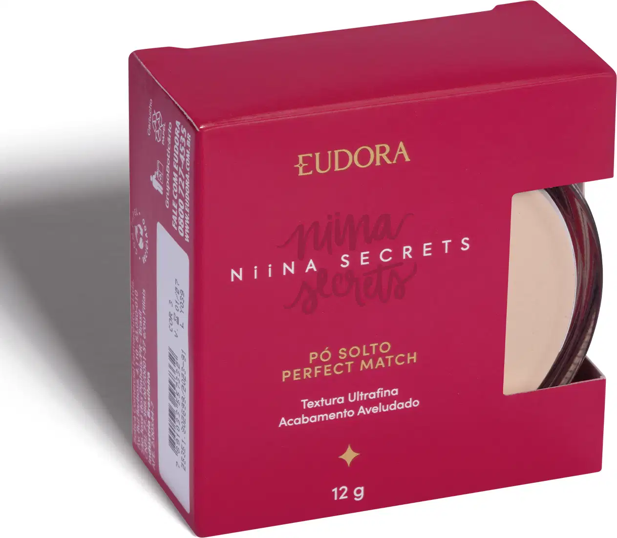 A imagem mostra o produto dentro de uma caixinha rosa escuro, com lateral semi-aberta, que dá pra ver uma parte do produto. A caixa tem logo da marca e linha escrito com letras douradas e branca.