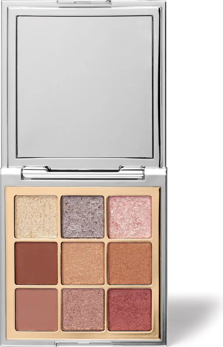 Paleta de sombras de olhos compacta com espelho integrado. Embalagem retangular de metal cromado. Nove sombras prensadas em tons neutros e rosados, variando de bege claro a marrom terroso e rosa envelhecido. Superfície das sombras com acabamento dourado.