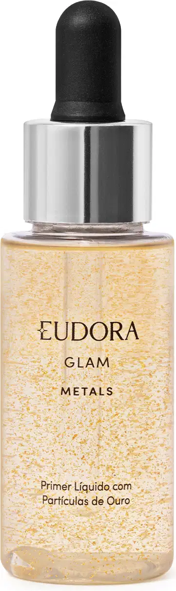 Primer líquido. Frasco transparente com tampa prateada e preta contendo um líquido dourado brilhante com partículas cintilantes. Rótulo dourado com o nome do produto e da linha. Embalagem simples destacando o aspecto metálico e iluminador do produto.