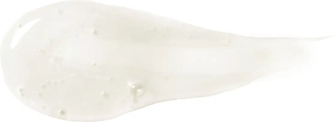 Textura do produto Shampoo de Siàge. Possui um formato alongado e irregular, com uma superfície esbranquiçada e com algumas manchas ou pontos visíveis. Não há rótulos, textos ou outras informações visíveis na embalagem.