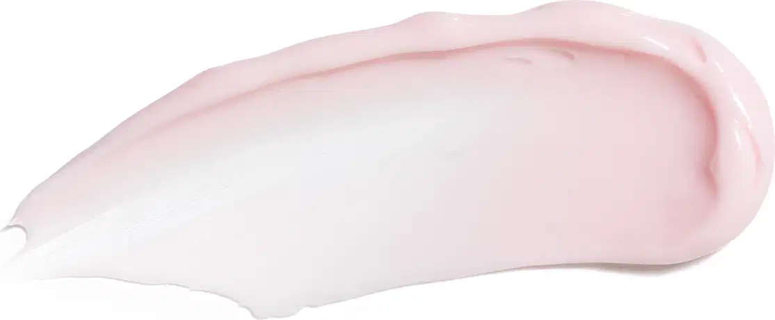 Textura do creme ou loção cosmética de cor rosa e branca. Possui uma forma arredondada e suave, com uma textura cremosa e brilhante. Não é possível identificar qualquer texto ou rótulo visível na imagem.