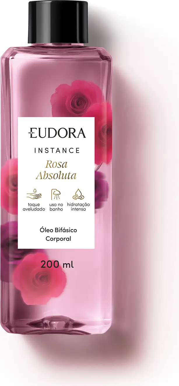 O produto apresentado é um óleo bifásico corporal da linha Instance Rosa Absoluta. O frasco é transparente, com um rótulo branco contendo o nome da marca, da linha e do aroma. A embalagem possui uma tampa preta e contém 200 ml do produto.