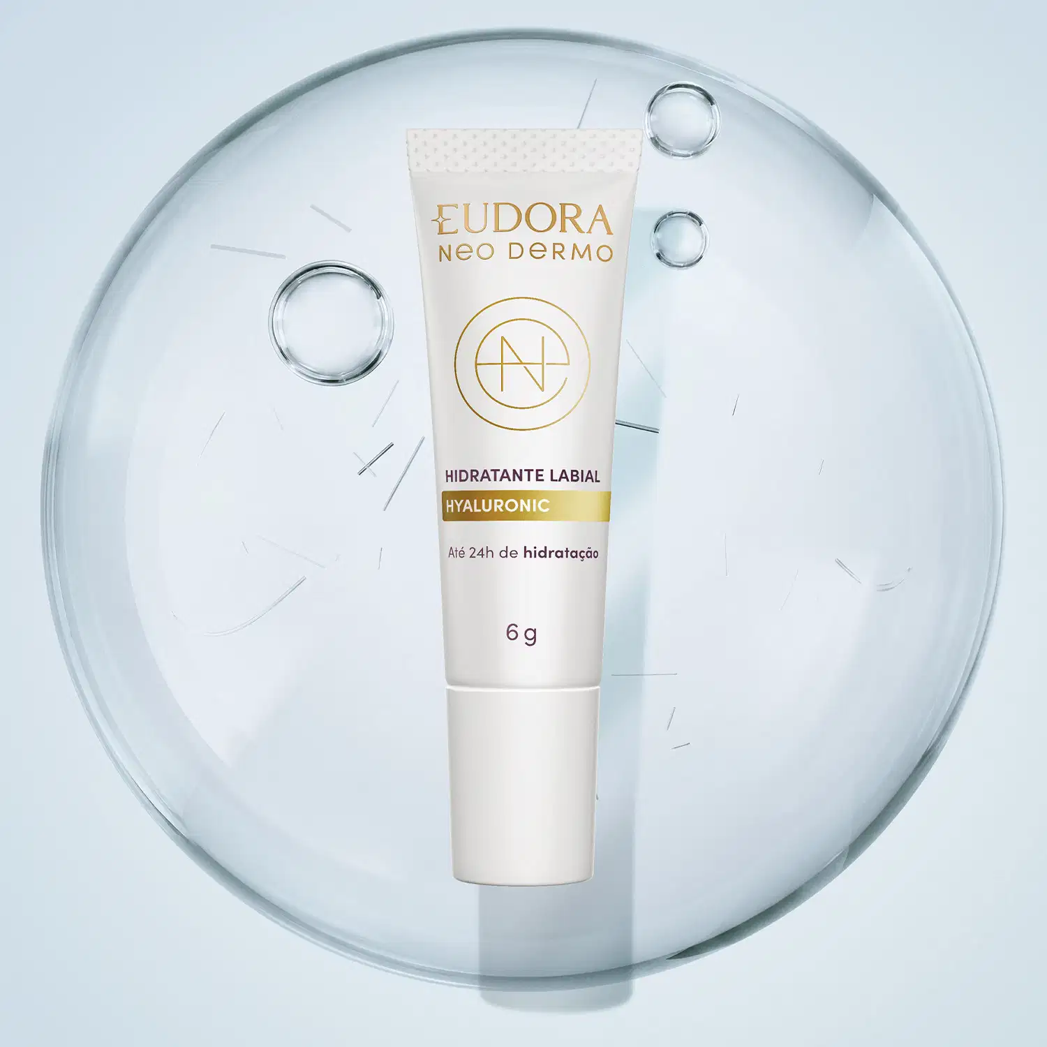 Tubo de hidratante labial branco da marca Eudora Neo Dermo. Abaixo dele, temos uma superfície arredondada, indicando a textura do produto: lisa, levemente brilhante e com bolhas se formando. Em ambiente claro e minimalista.