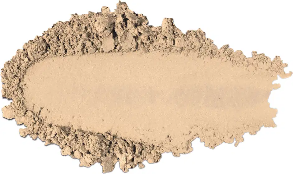 Textura de pó compacto com acabamento aveludado e superfície irregular, em quantidade moderada sobre fundo branco.