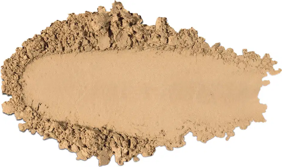 Textura de pó compacto com acabamento aveludado e superfície irregular, em quantidade moderada sobre fundo branco.