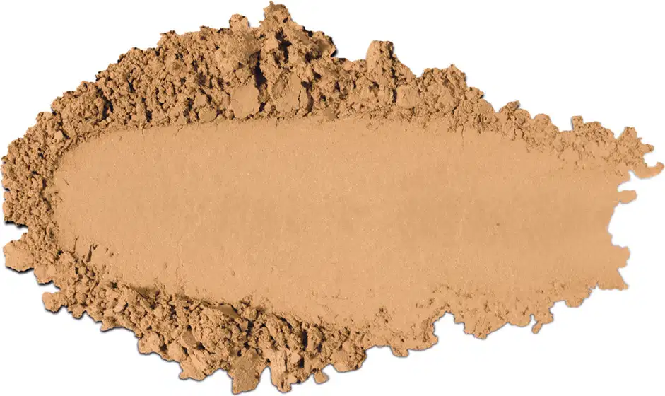 Textura de pó compacto com acabamento aveludado e superfície irregular, em quantidade moderada sobre fundo branco.