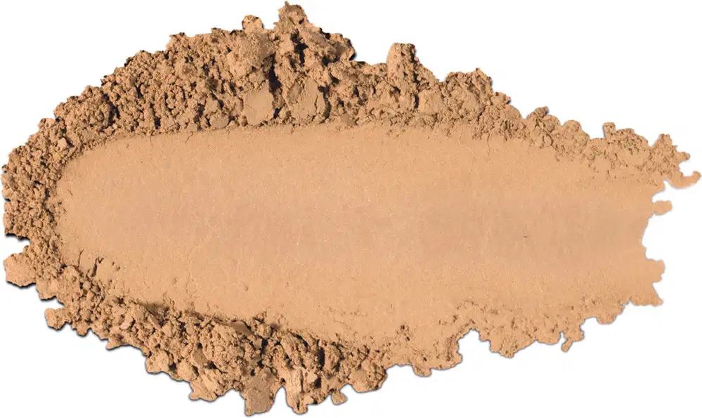 Textura de pó compacto com acabamento aveludado e superfície irregular, em quantidade moderada sobre fundo branco.