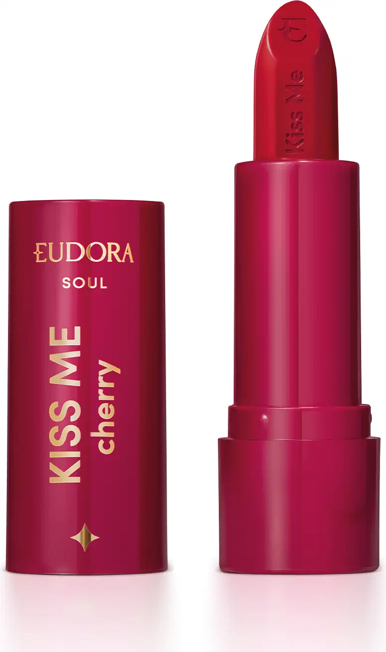 O produto apresentado é um batom da linha Soul da marca Eudora, "Kiss me cherry". A embalagem é composta por um tubo de cor rosa escuro, com o nome da marca e da linha impressos em dourado. O batom em si possui uma tonalidade vermelha.