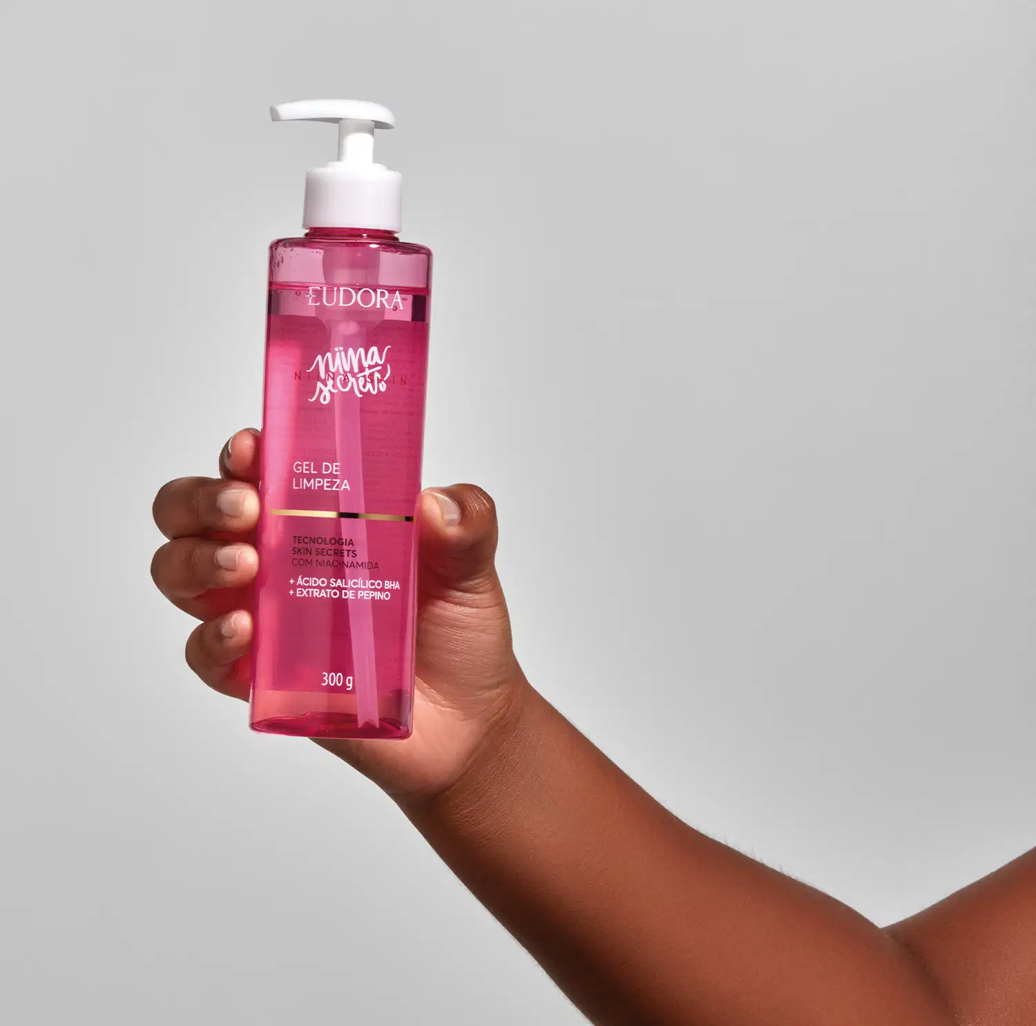 Frasco do produto Gel de Limpeza Niina Secrets sendo segurado por uma mão feminina.