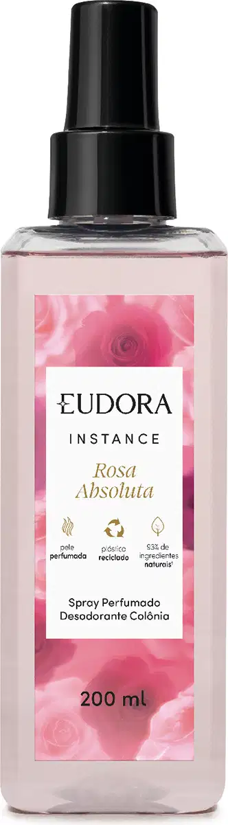 O produto apresentado é um spray perfumado desodorante da linha Instance Rosa Absoluta. O frasco é de plástico transparente com um rótulo rosa, destacando informações sobre o produto. Possui um design elegante e minimalista, com uma tampa preta.