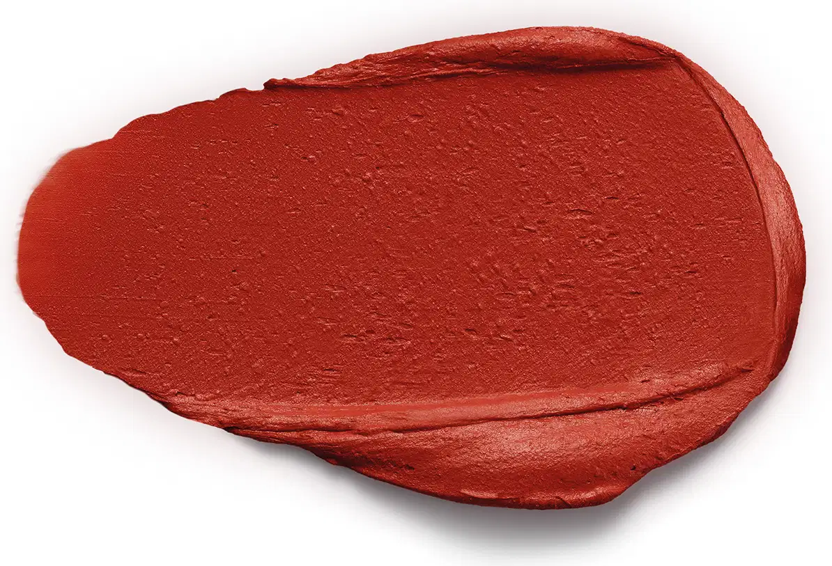 Textura de batom de cor vinho intensa, com acabamento matte e consistência aveludada, aplicada sobre superfície branca.