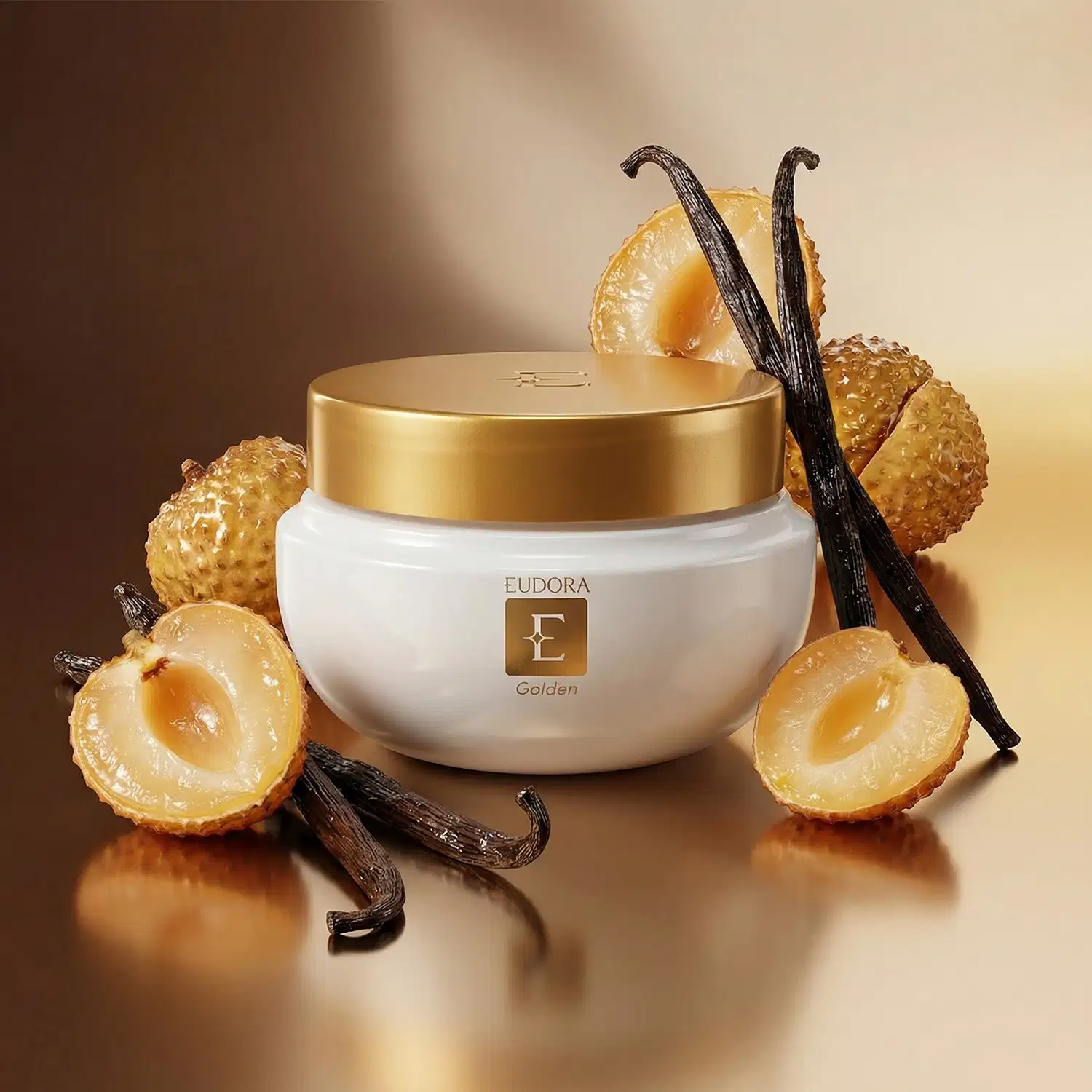 Produto da marca Eudora Golden, destacado em recipiente branco e dourado, rodeado por elementos decorativos como lichia dourada e baunilha, em cenário com tons quentes e iluminação suave.