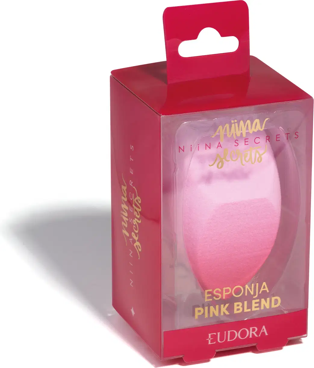 Esponja Pink Blend dentro da embalagem, que é transparente na frente, sendo possível ver o produto, mas rosa nos demais lados. Escritos em dourado.