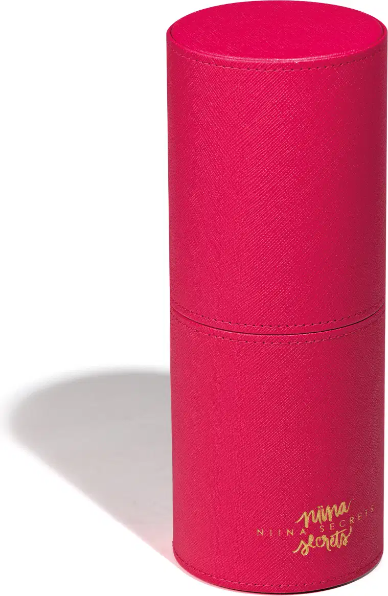 Embalagem cilíndrica de cor rosa vibrante, com textura aveludada e rótulo com a marca "Nina Secrets" em dourado. Trata-se do Estojo Organizador para Pincéis Pink Case.