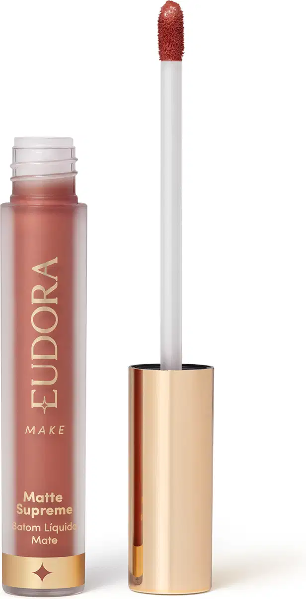 Batom Líquido Matte Supreme em embalagem transparente com tampa dourada e aplicador do tipo bastão. Produto com design minimalista e rótulo dourado no frasco.