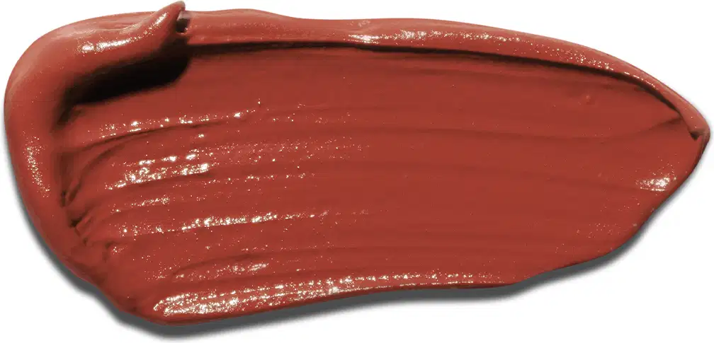 A textura do produto de beleza apresenta uma aparência cremosa e brilhante, com uma coloração marrom terracota intensa e uniforme. Sua consistência parece ser suave e macia, indicando uma fórmula cremosa e de fácil aplicação.