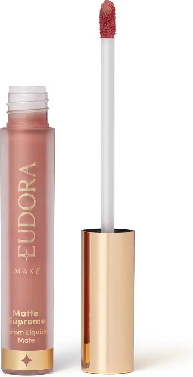 Batom Líquido Matte Supreme em embalagem transparente com tampa dourada e aplicador do tipo bastão. Produto com design minimalista e rótulo dourado no frasco.