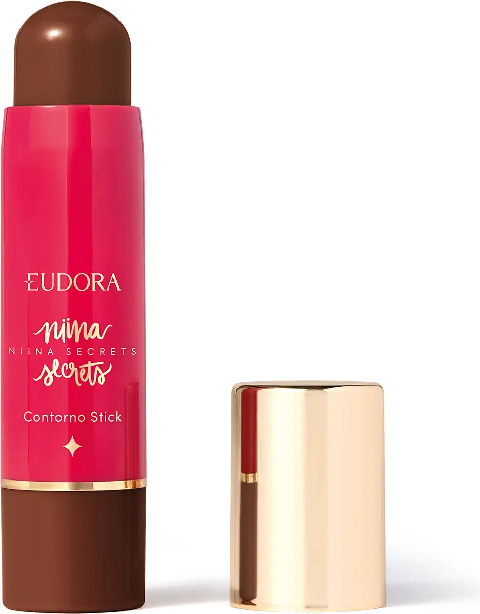 O produto apresentado é um contorno em bastão da linha Niina Secrets. A embalagem é cilíndrica e de cor rosa vibrante, com o nome da marca e da linha impressos em letras douradas. A embalagem também possui um detalhe dourado na parte superior.