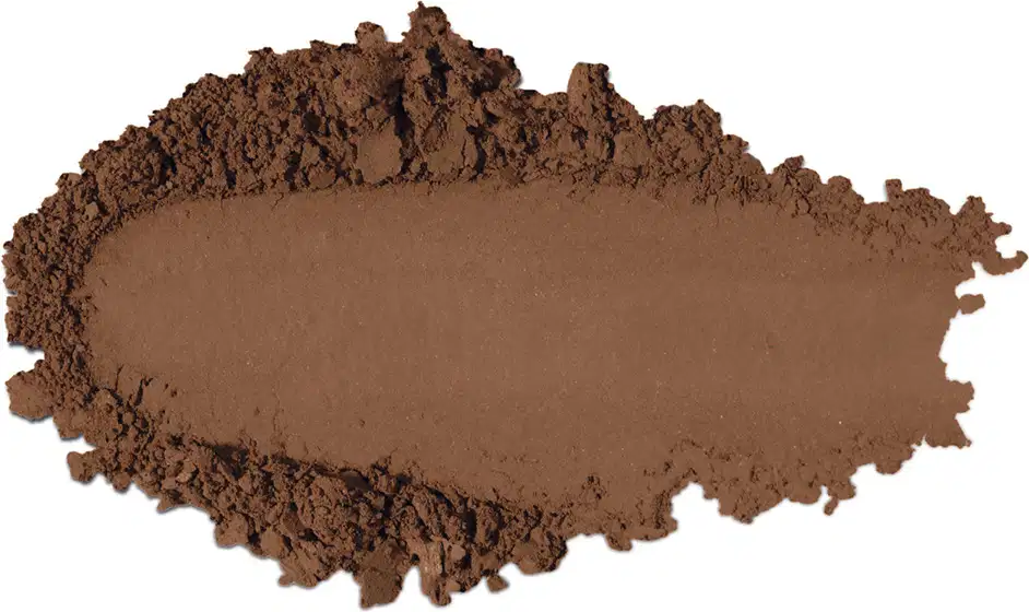 Textura de pó compacto com acabamento aveludado e superfície irregular, em quantidade moderada sobre fundo branco.