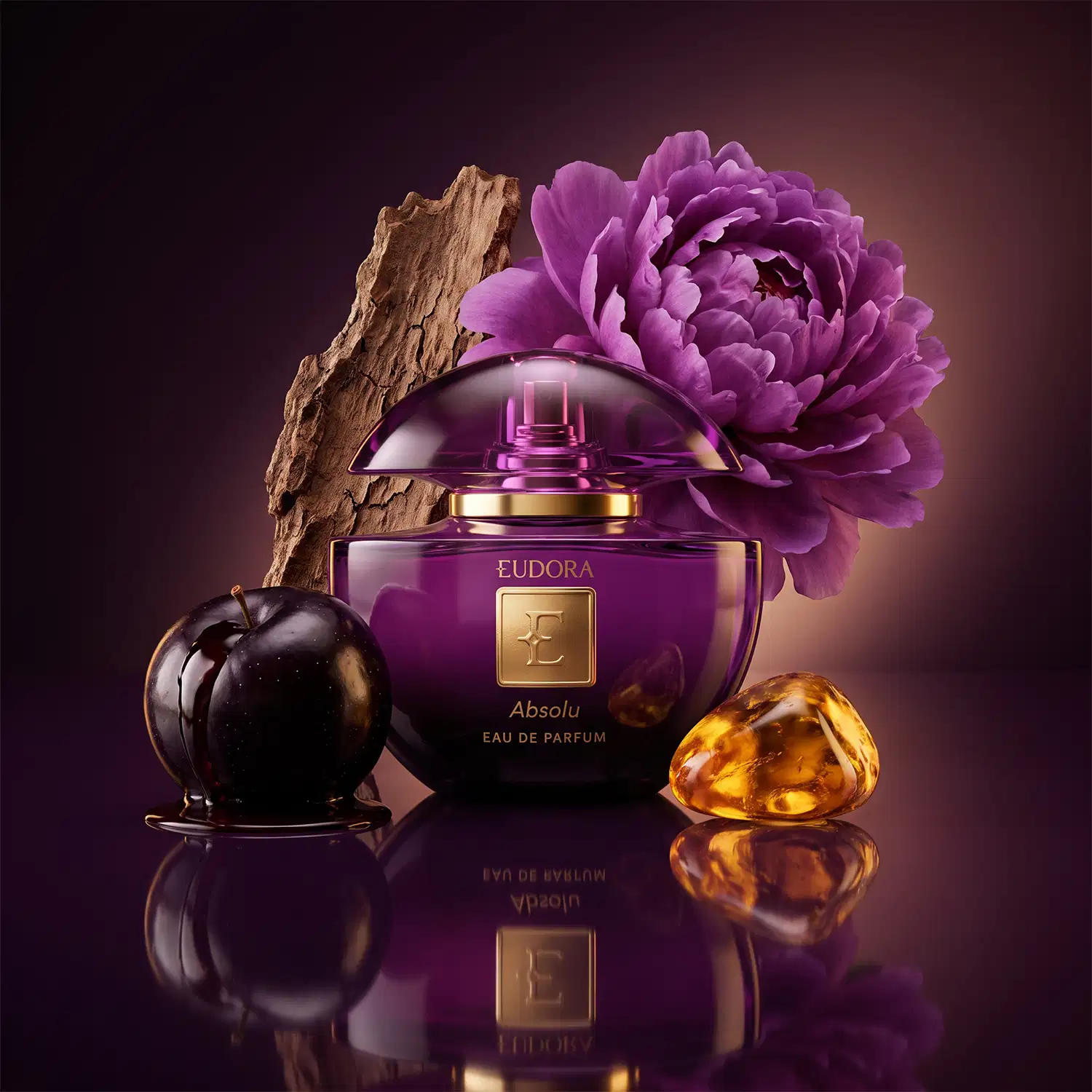 Frasco de perfume Eudora Absolu em embalagem roxa com detalhes dourados, acompanhado de uma flor de peônia roxa e uma maçã preta sobre fundo escuro.