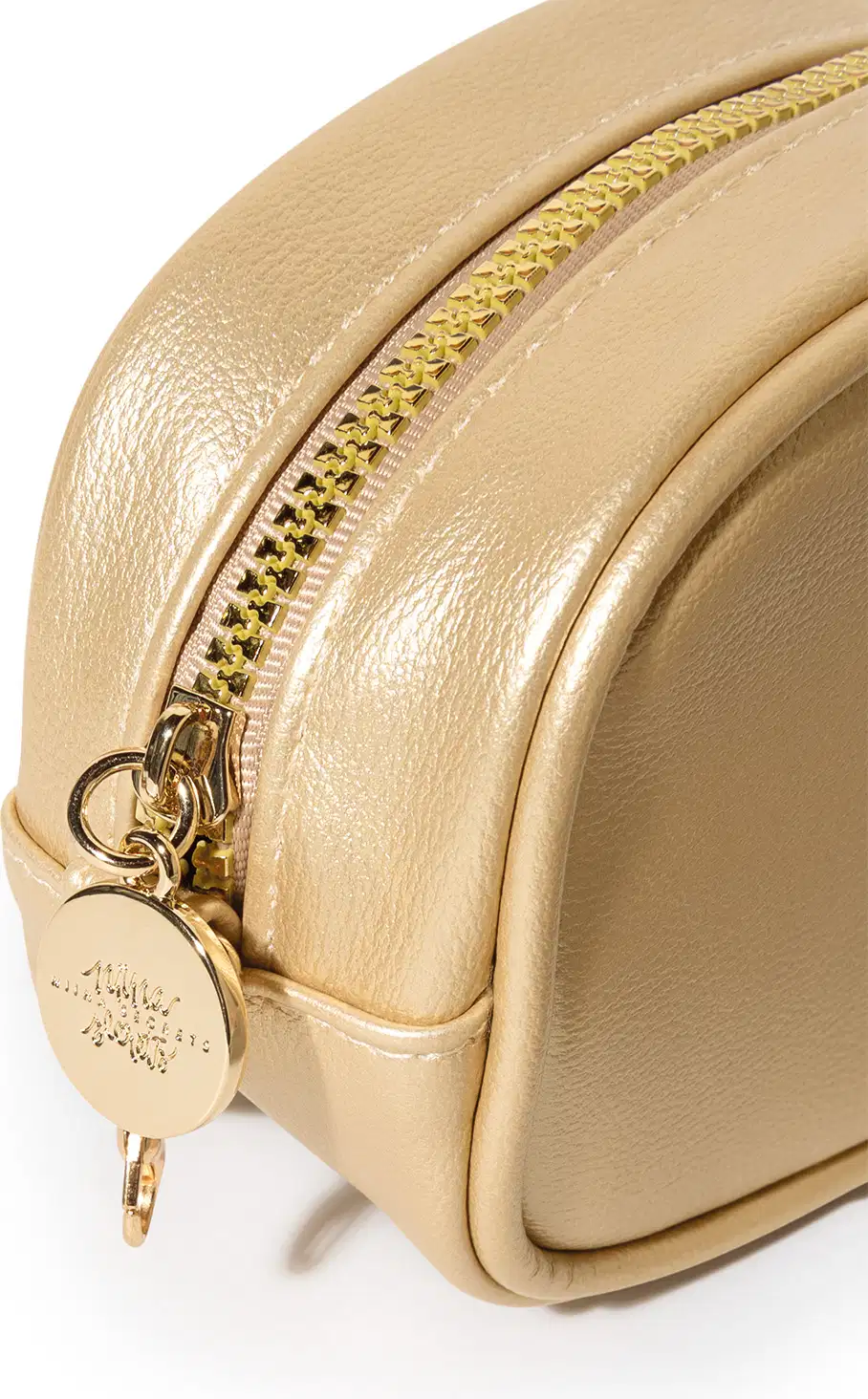 Imagem angulada da bolsa dourada com zíper e pingente redondo. A bolsa possui uma superfície lisa e brilhante, com detalhes em dourado, incluindo o zíper e o pingente. Trata-se de um item de design elegante e sofisticado.