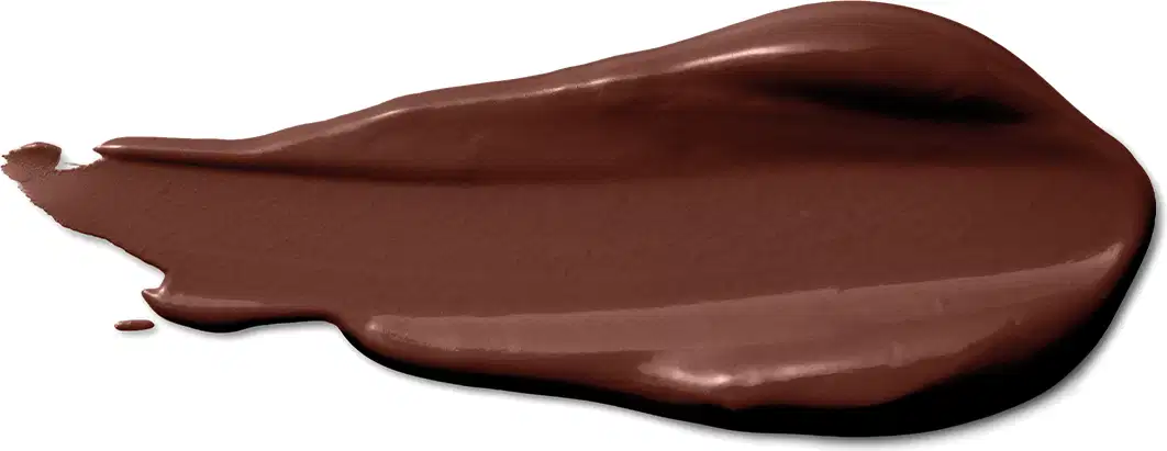 A textura do produto corretivo líquido apresenta uma aparência cremosa e suave, com uma tonalidade marrom escura e uniforme. 