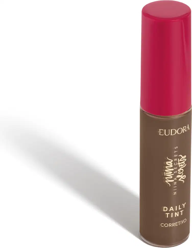 Corretivo líquido Eudora Daily Tint com frasco cilíndrico marrom e tampa rosada, rótulo com texto em dourado.
