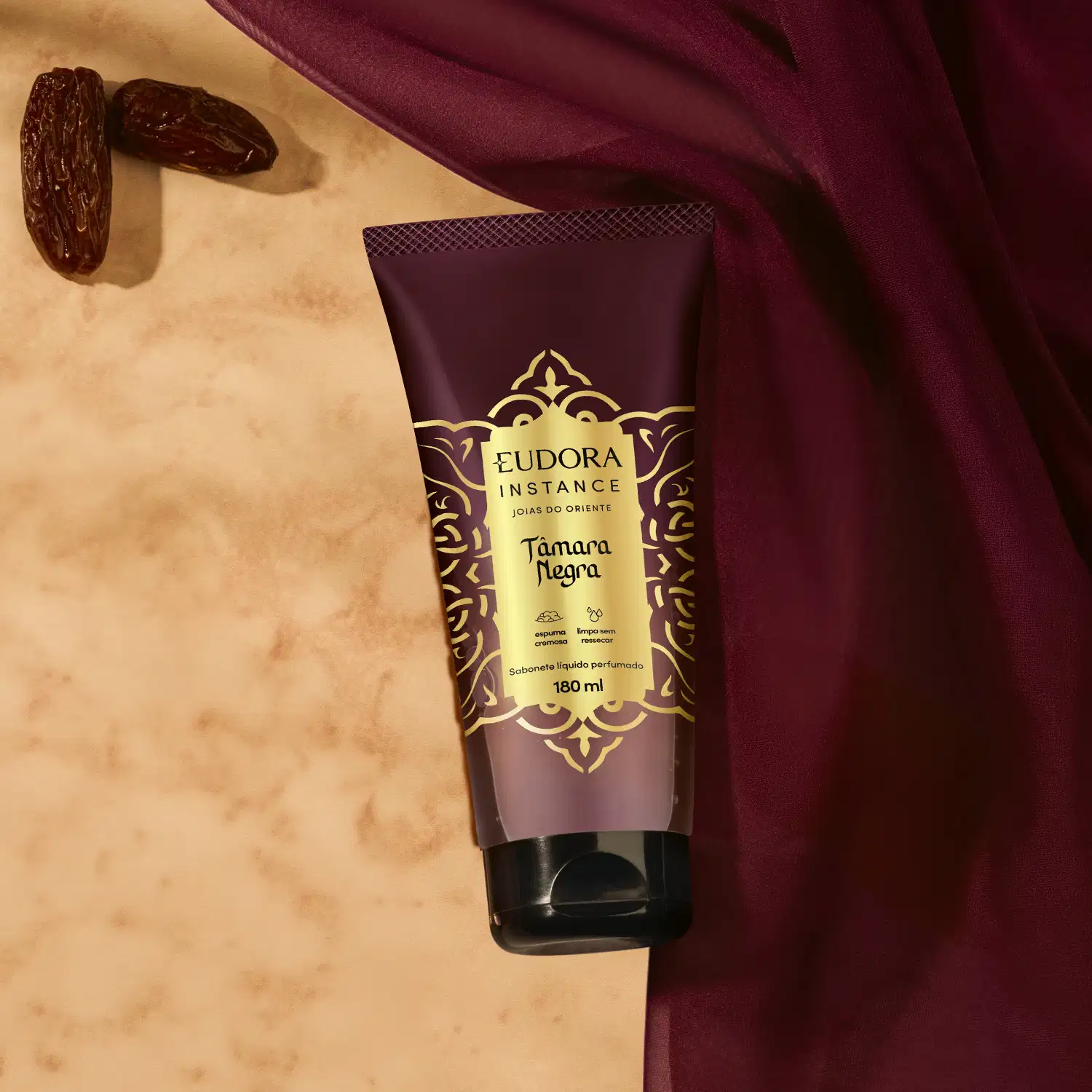 Sabonete líquido perfumado Eudora Instance Tâmara Negra em embalagem tube de 180ml. Frasco com predominância de cores marrom e dourado, decorado com padrões ornamentais. Rótulo destaca "espuma cremosa" e "limpa sem ressecar".