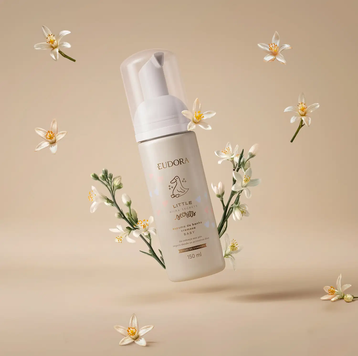 Ambiente de beleza minimalista e natural, com flores brancas delicadas em fundo bege, destacando o produto Eudora Little Secrets, uma espuma de banho com design elegante e moderno.