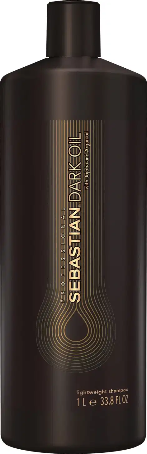 Shampoo leve da marca Sebastian Professional. Embalagem plástica marrom escura opaca com detalhes em dourado. Rótulo com o nome da marca e do produto "Sebastian Dark Oil" em letras douradas e estilizadas.