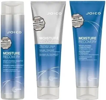Três itens da marca Joico: shampoo, condicionador e creme de tratamento da linha Moisture Recovery, em embalagens de plástico com cores azul, branco e cinza.