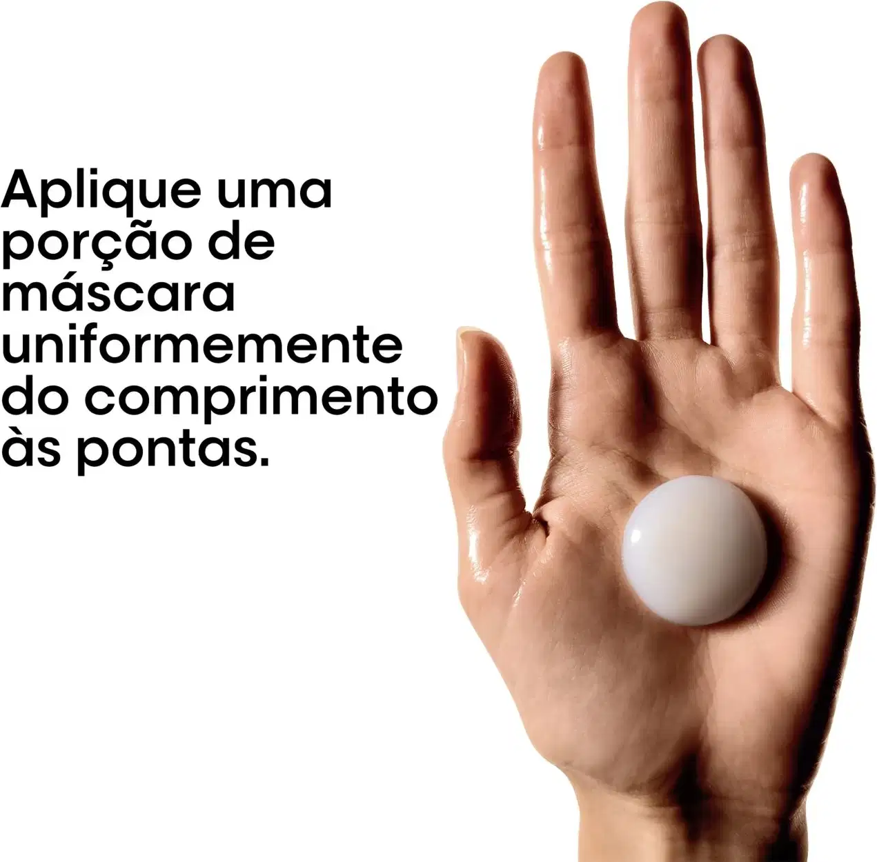 Imagem de uma mão aplicando uma porção de máscara capilar uniformemente nas pontas dos dedos, sugerindo um procedimento de tratamento capilar profissional da marca L'Oréal Professionnel.